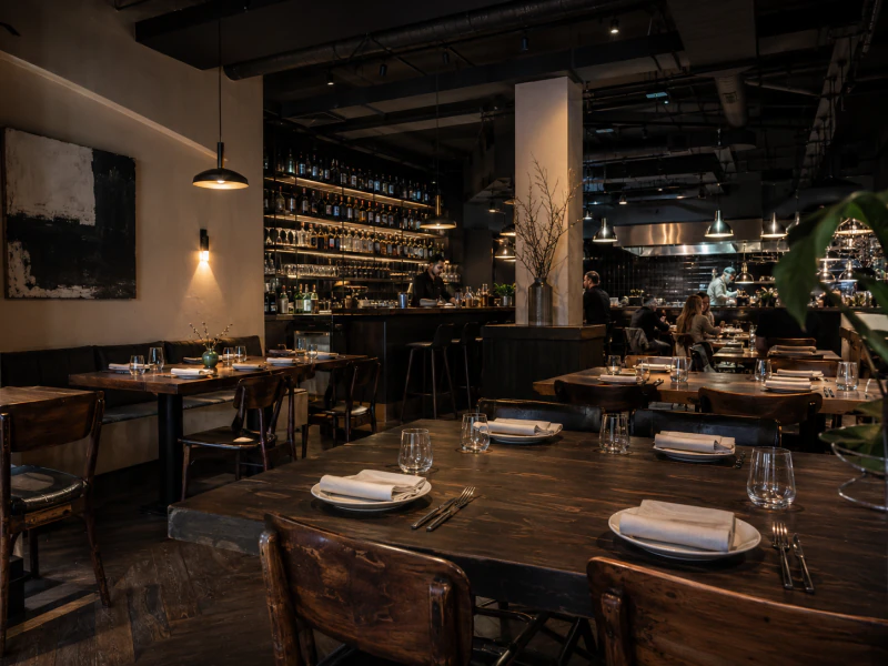 Restaurant interior with an open kitchen and prepared tables